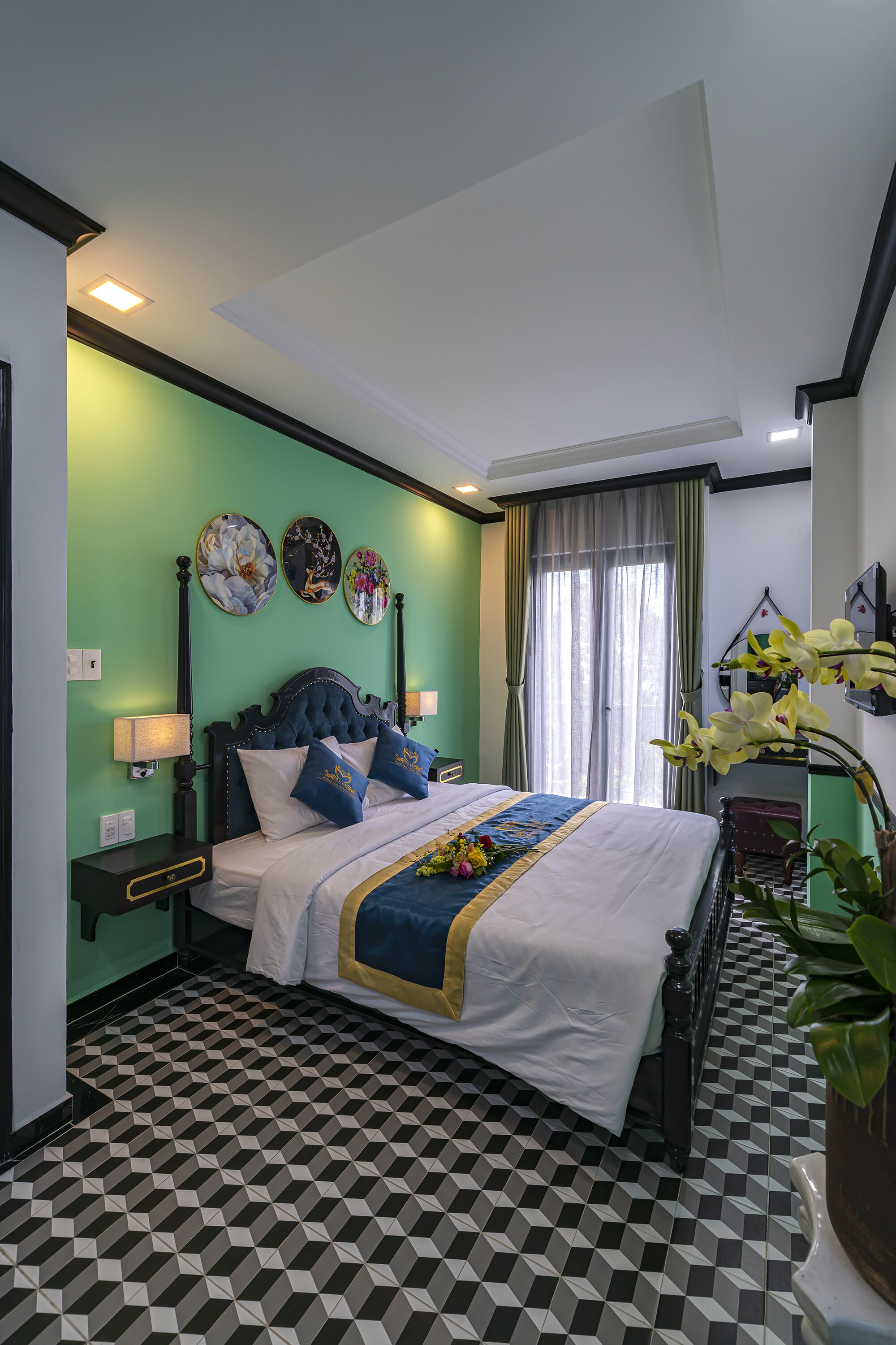 Un dormitorio con cama, mesitas de noche, una ventana con cortinas y suelo estampado.