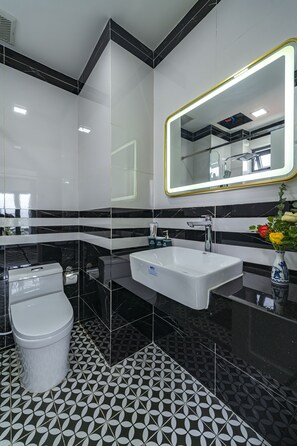 A modern bathroom with a white sink, a toilet, and a large mirror with a gold frame. - Collection O VyVy Airport Hotel (Ho Chi Minh City)