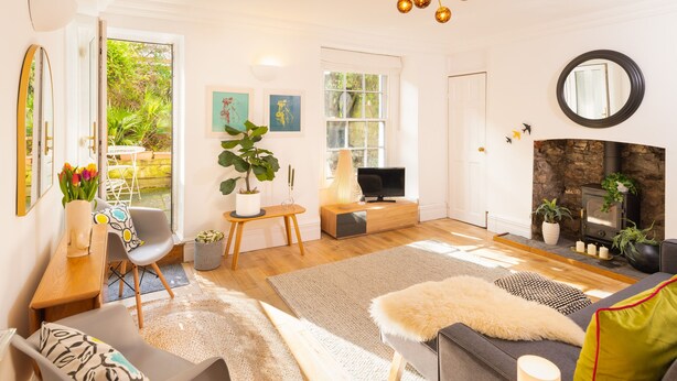 Un salon moderne doté d’une cheminée, d’un téléviseur et d’un coin repas avec une table et des chaises.