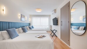 A hotel room with two beds, a large mirror, and a TV on the wall. - Granada Suites by Olala Homes (Granada)