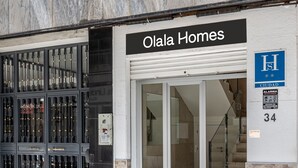 A storefront with a sign reading "Olala Homes" and a blue "H" sign indicating a hotel. - Granada Suites by Olala Homes (Granada)