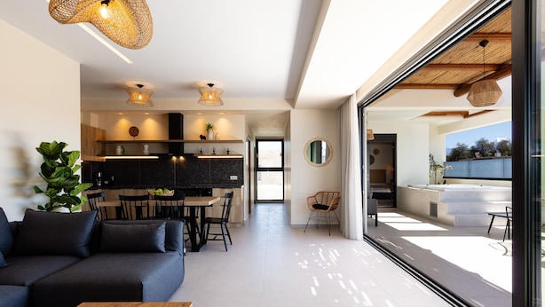 Un intérieur moderne comprenant une cuisine, un coin repas et un salon avec une grande fenêtre.