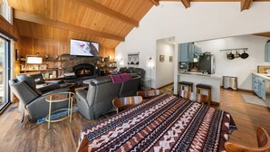 Un amplio salón con chimenea, un sofá, una mesita de centro y una alfombra estampada.