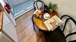 Un comedor con una mesa preparada para dos, un cuadro enmarcado de Arundel, Inglaterra, y una obra de arte colgada en la pared con un árbol.