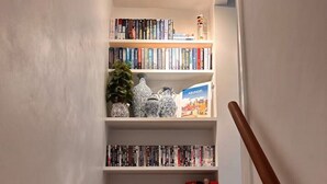 Una escalera con una estantería llena de libros y objetos decorativos.