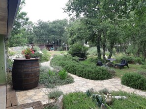 A garden with a stone pathway, a wooden barrel, and outdoor furniture.