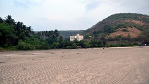 A sandy beach with a building in the background. - The Byke Skylark Seafront Resort, Dapoli (Dapoli)