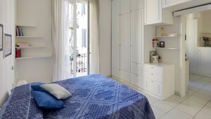 Ein Schlafzimmer mit Bett, Kleiderschrank und einem kleinen Schreibtisch.