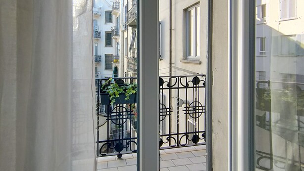 Blick von einem Balkon mit Metallgeländer und Blumentöpfen.