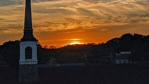 Un monumento alto con un pico puntiagudo, sobre un cielo al atardecer con nubes.