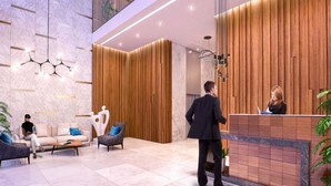 A modern lobby with a reception desk, seating area, and a high ceiling with lighting fixtures. - Nasma Luxury Stays - Riviera 10 (Dubai)