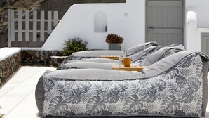 A white building with a stone wall, a wooden fence, and a door. - El Verano Hideaway Villa (Santorini)