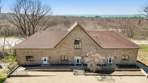 A two-story brick building with a gabled roof, a small central window, and a front entrance with a door and steps. - Classy Cabin | Beaches | Grand Mere | Wineries (Stevensville)