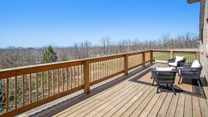 A wooden deck with outdoor furniture and a view of a forested area. - Classy Cabin | Beaches | Grand Mere | Wineries (Stevensville)