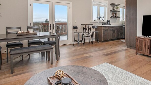A spacious kitchen with a dining area, large windows, and a view of the outdoors. - Classy Cabin | Beaches | Grand Mere | Wineries (Stevensville)