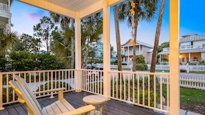 A wooden deck with a white railing, a single Adirondack chair, and a small table. - Andrea's Island*Golf Cart*Bikes*BeachSvc+ExtraGear! (DESTIN)