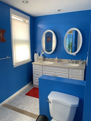 A bathroom with blue walls, a white sink, two mirrors, and a toilet. - 4 Bedroom upstairs unit only 2 blocks to the beach! (Bradley Beach)
