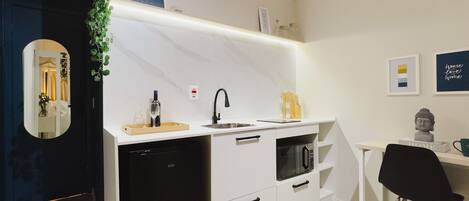 A modern kitchen with white cabinetry, a black dishwasher, and a built-in oven.