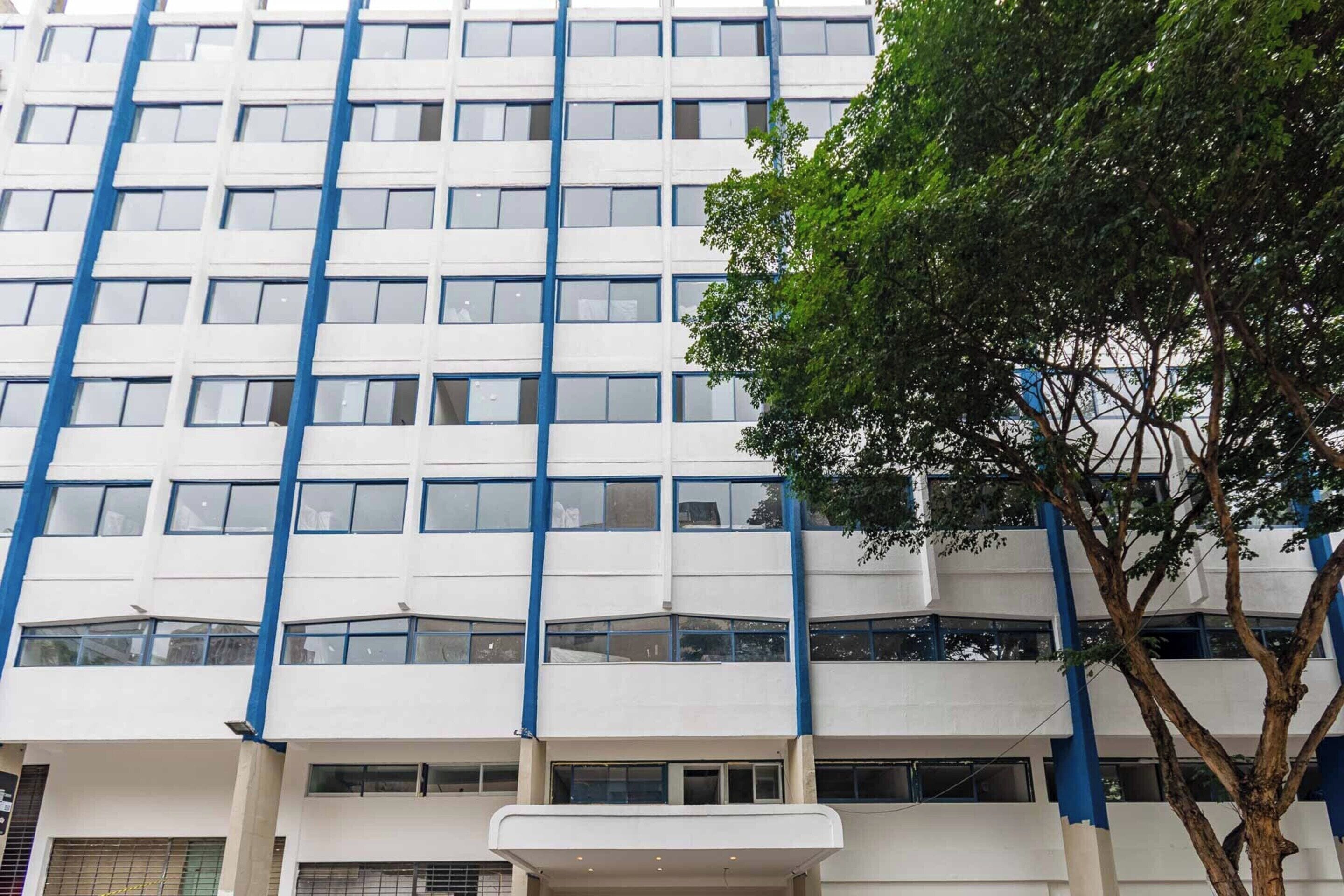 Ein mehrstöckiges Gebäude mit einer rasterförmigen Fassade und blauen Strukturelementen.