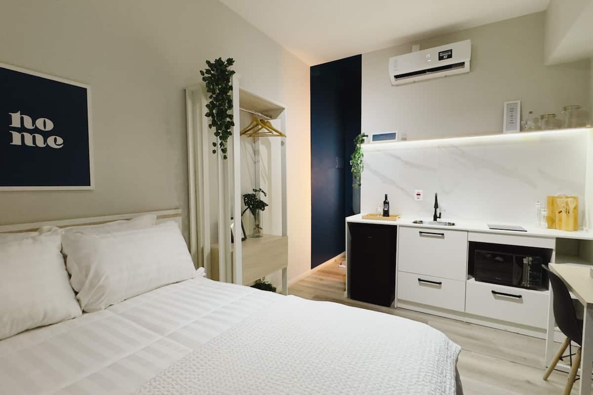 Une chambre à coucher moderne avec un lit, une table de chevet et une armoire intégrée.