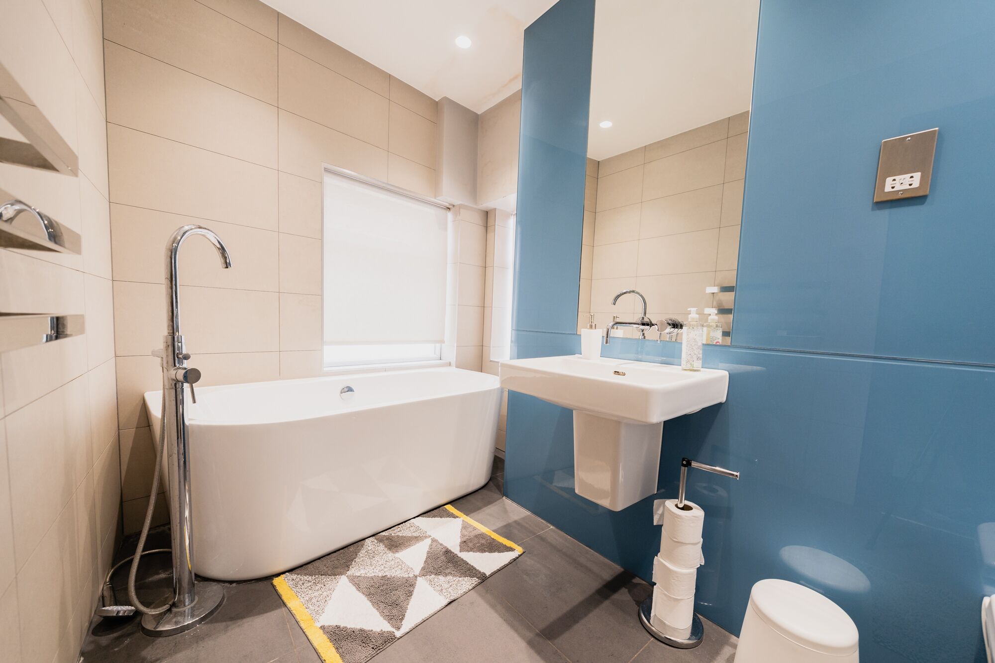 A modern bathroom with a freestanding bathtub, a sink, and a toilet.