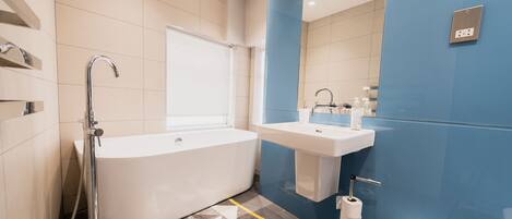 A modern bathroom with a freestanding bathtub, a sink, and a toilet.