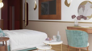 A modern hotel room with a bed, a desk, a chair, and a small table with decorative items. - Baron Amédée Armand Hotel & Spa Marseille - Mgallery (Marseille)