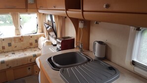 A compact kitchenette with a sink, a toaster, and a kettle. - Lovely Caravan Near Notts and Newark (Newark)