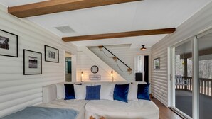 Una sala de estar acogedora con un sofá blanco, cojines azules y una mesa de centro de madera.
