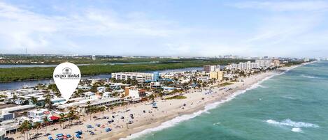 A coastal cityscape with a beach, hotels, and a marina.