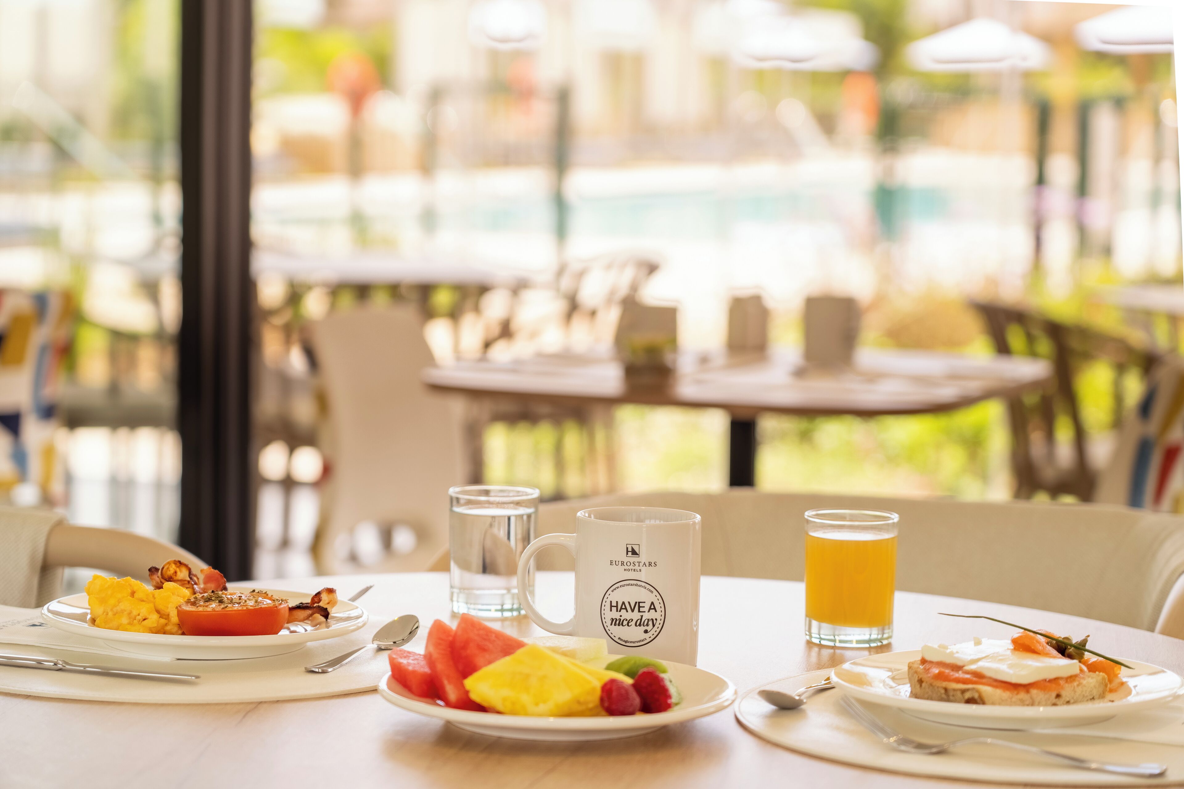 A breakfast setting with a plate of food, a mug, and a glass of orange juice.