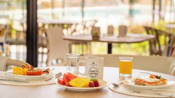 A breakfast setting with a plate of food, a mug, and a glass of orange juice.