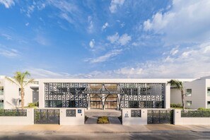 The entrance to Eurostars Oasis Marbella with a modern architectural design, featuring a geometric facade and a clear sky.