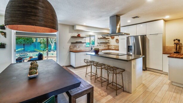 A modern kitchen with a large island, stainless steel appliances, and a pendant light. - Glamorous Renovated Desert Oasis, Heated Pool, Tub (Scottsdale)