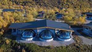 A log cabin with three large circular windows and a sloped roof. - Utsjoki Arctic Resort (Utsjoki)