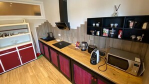 A compact kitchen with a wooden countertop, a built-in microwave, a coffee maker, and a red cabinet. - NiGiNo house sleeps 6, private pool and garden (Donnini)