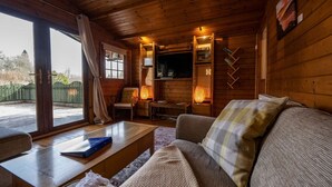 En mysig stuga med en soffa, ett soffbord och en tv.