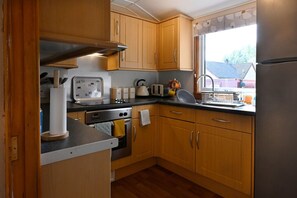 Een koelkast, een kinderstoel, kookgerei, borden en bestek