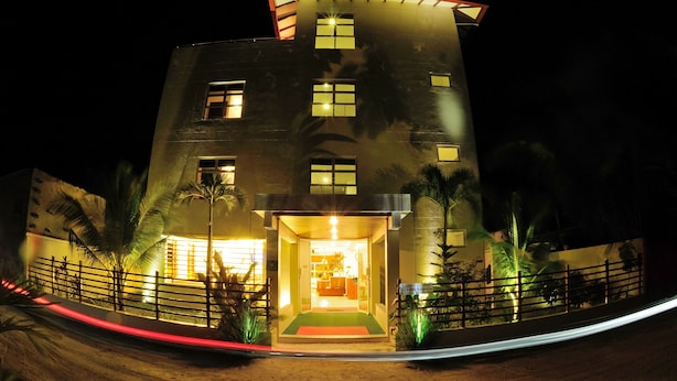 A modern building with a curved facade, multiple windows, and a well-lit entrance. - Antares Dhangethi (Dhangethi)