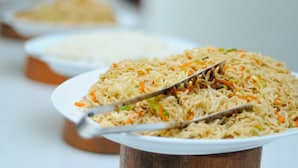 A bowl of fried noodles with vegetables and a spoon. - Antares Dhangethi (Dhangethi)