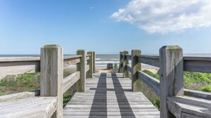 A wooden boardwalk leading to a beach with a vehicle parked at the end. - Beach Front Cottage with Beautiful Ocean Views! (Crystal Beach)