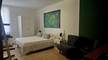 A bedroom with a bed, a nightstand, a chair, a desk, a painting, and a wardrobe.