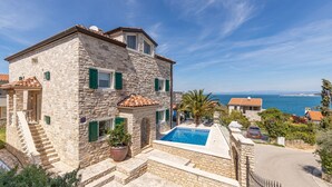 A stone building with a swimming pool, a staircase, and a view of the sea. - Beautiful Villa Milena with swimming pool (Crveni Vrh)