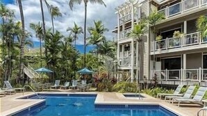 A pool area with lounge chairs and palm trees. - Grand Champions Two Bedrooms - Ocean View by Coldwell Banker Island Vacations (Kihei)