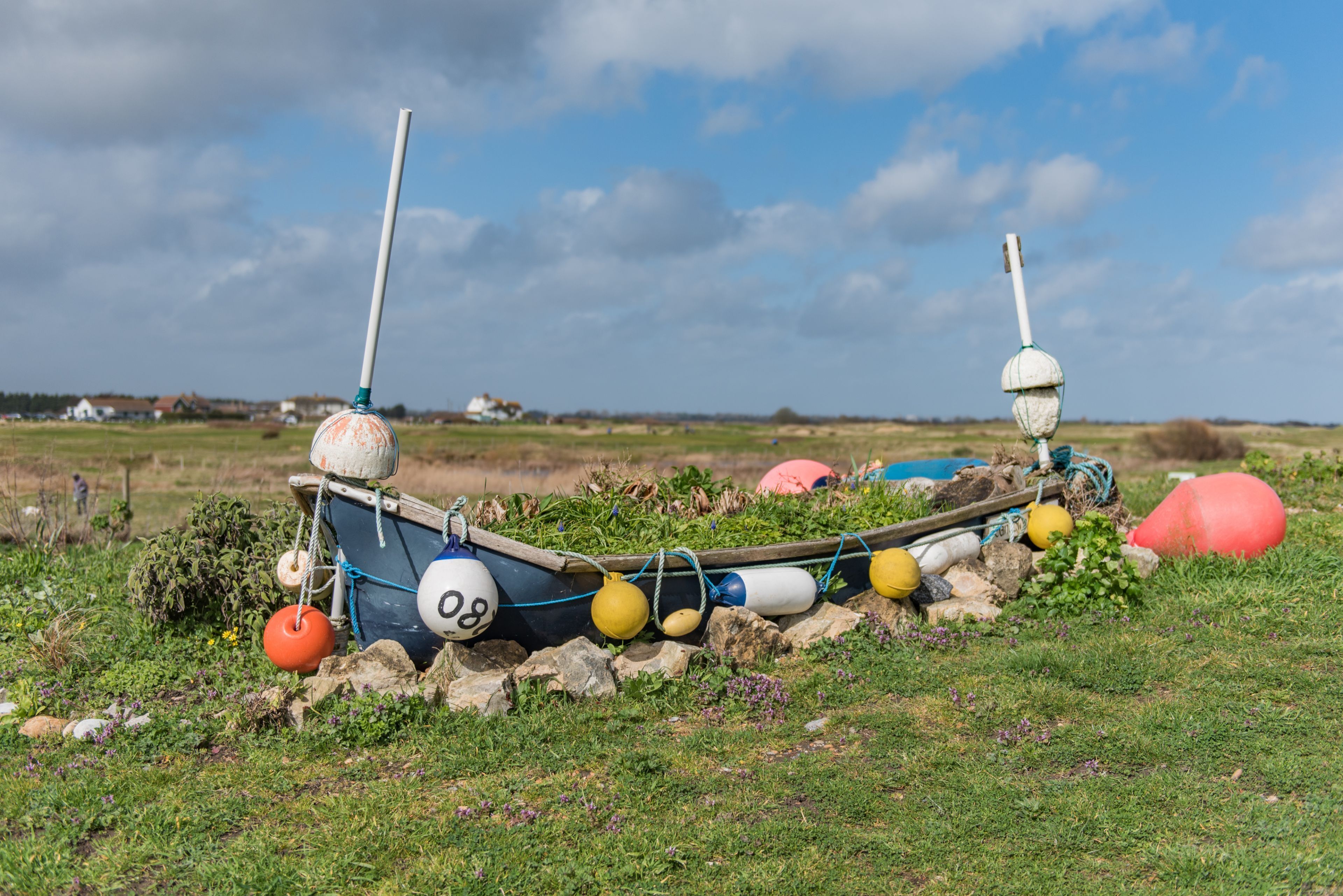 A boat with buoys and a buoyant object on a grassy field.