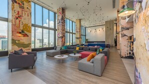 A spacious lounge with large windows, a modern sofa set, and a unique wall art installation. - Miami Panorama Apartment - City view  (Miami)