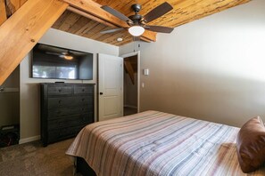 A bedroom with a bed, a dresser, a ceiling fan, and a television. - Rustic & Modern 3BDR Tahoe Cabin (Tahoe City)