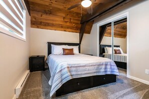 A bedroom with a bed, nightstands, a ceiling fan, and a window with blinds. - Rustic & Modern 3BDR Tahoe Cabin (Tahoe City)
