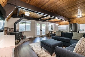 A spacious living area with a fireplace, a sofa set, and a dining area. - Rustic & Modern 3BDR Tahoe Cabin (Tahoe City)