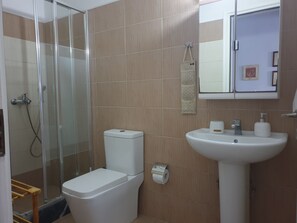 A bathroom with a toilet, sink, and shower.